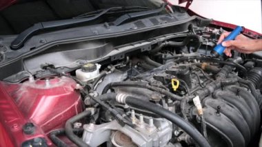 Asyalı Tamirci: Uyarıcı akıllı telefondan motora el feneri motoru kontrolü yap. Araba mühendisliği ile hizmet sigortası için kırmızı araba. Otomotiv tamir otomobili için kırmızı araba.