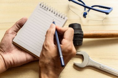 Elinde not defteri olan el işi uzmanları, not müfettişleri için masa başında sanayi veya fabrikayı kontrol ediyor. Metafor Kalite Denetleme veya Üretim Hızı Müşterilere en iyi kalite.