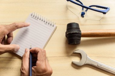 Elinde not defteri olan el işi uzmanları, not müfettişleri için masa başında sanayi veya fabrikayı kontrol ediyor. Metafor Kalite Denetleme veya Üretim Hızı Müşterilere en iyi kalite.