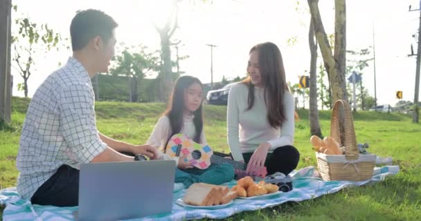 Den Unga Familjen Sitter Parken Och Har Picknick Dottern Håller — Stockvideo