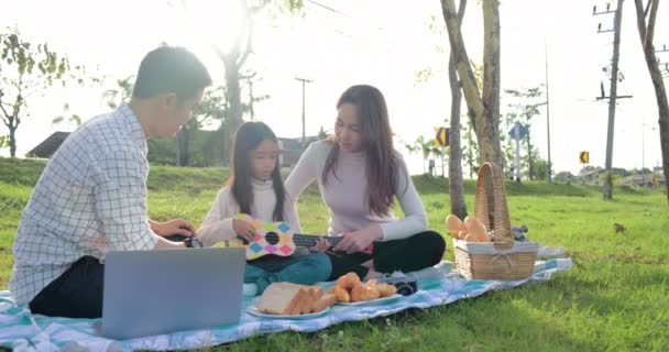 Fiatal Család Parkban Piknikeznek Lányuknál Van Kis Gitár — Stock videók