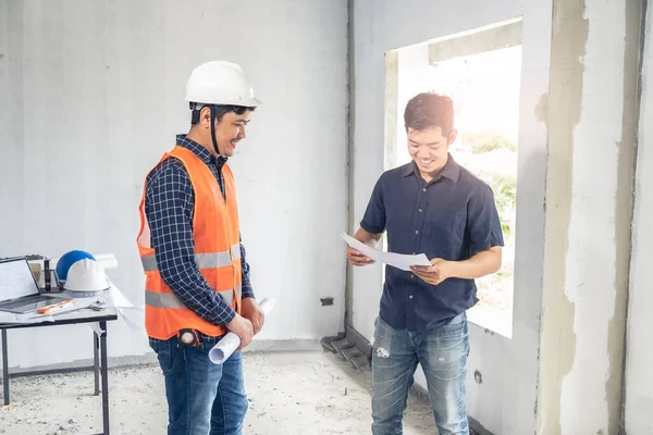 Young asian inspector checking house with foreman engineering home inspection building house Walk home inspection with looking and pointing construction for check building home on job site to customers