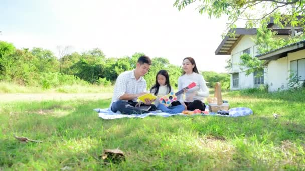 Família Asiática Bonito Tocando Guitarra Cantando Músicas Parque Durante Piquenique — Vídeo de Stock