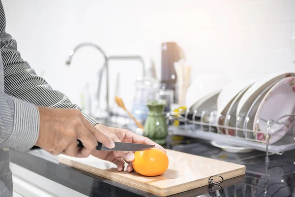 Blurred man asian cooking in kitchen of home He hands cutting vegetables and cutting fruit in the kitchen   to great hand on microwave in kitchen blurred background