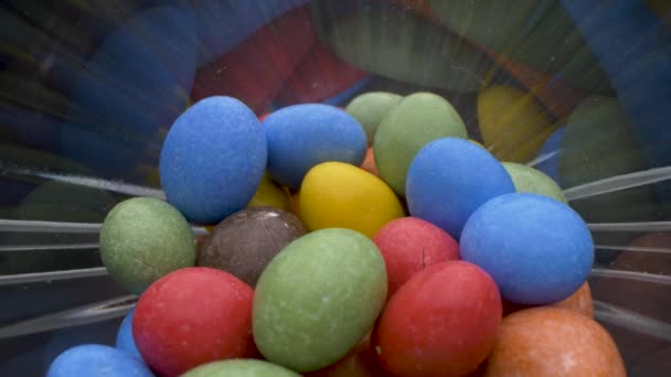 Colpo da vicino di caramelle al cioccolato che cadono dal vetro. Donna prende alcune caramelle colorate, macro vista. — Video Stock
