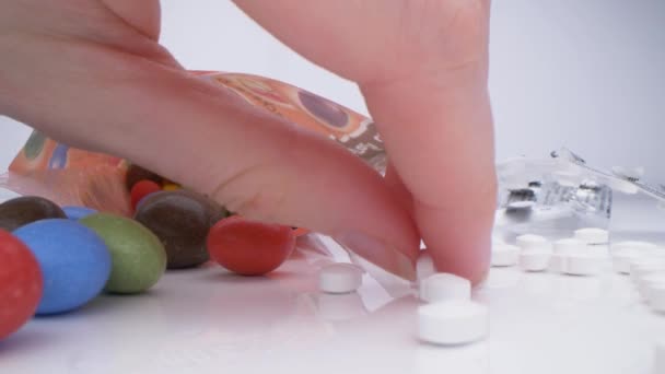 Bağımlılık. Makro insanların şeker niyetine uyuşturucu yediği görüşü. Eş anlamlı şeker ve haplar. Beyaz haplar, renkli şekerler.. — Stok video