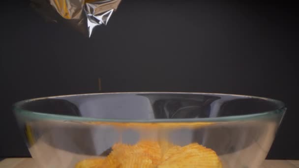 Vista al rallentatore della donna che riempie la ciotola vuota con gustose patatine. Preparare spuntini per la sera con gli amici dopo la quarantena. — Video Stock