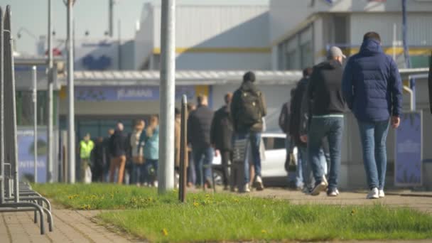 Vista borrosa y de enfoque lateral de las personas que están en la fila para recibir su vacuna Covid-19. Vacunación mundial. — Vídeos de Stock