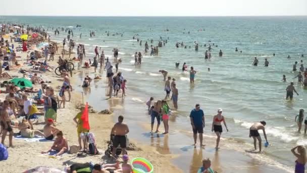 Palanga, Lithuania - Seaside - June 2021 - Moving side view of overcrowded seaside after quarantine. People want to rest after long lasting pandemic. No face mask or other security measures. — Stock Video