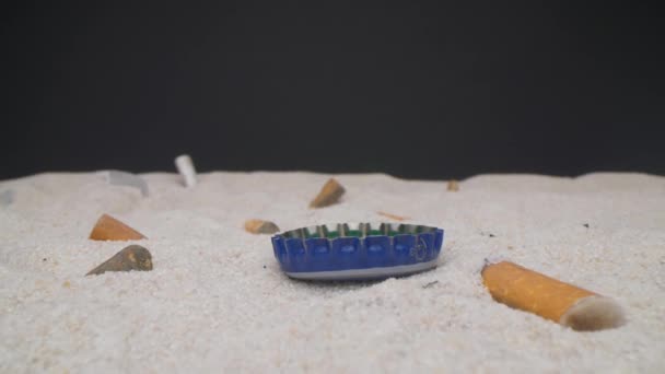 Primo piano vista telecamera della spiaggia inquinata. Ci muoviamo davanti a gente che butta spazzatura sulla sabbia. Problema globale. Studio shot, obiettivo sonda. — Video Stock