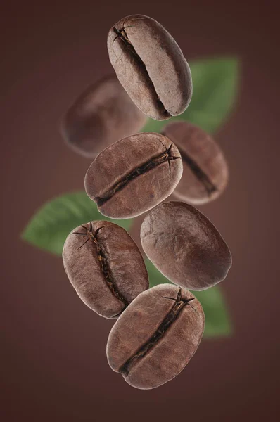 Kahverengi Arka Planda Yaprakları Olan Kahve Çekirdekleri Yakın Çekim — Stok fotoğraf