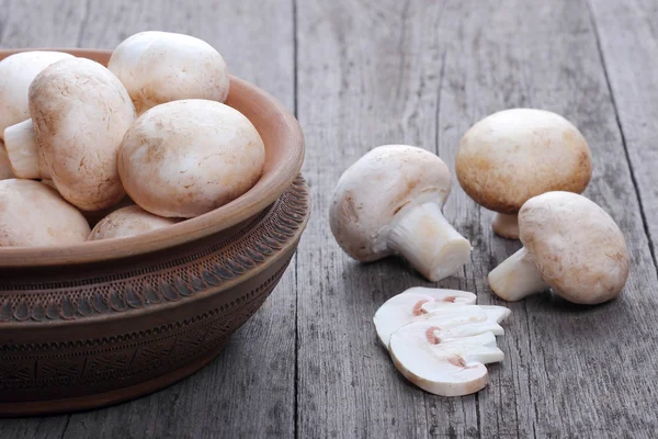 Champignons in a ceramic plate on old wood table — Stock Photo, Image