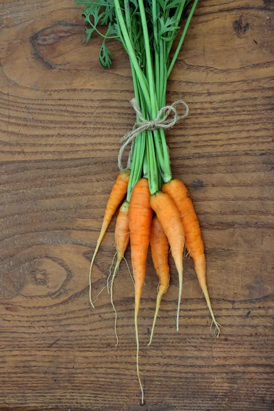 Bunch of fresh carrot on a wooden background — Stock Photo, Image
