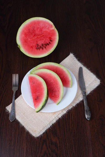 Sliced watermelon on white plate with knife and fork — Stock Photo, Image