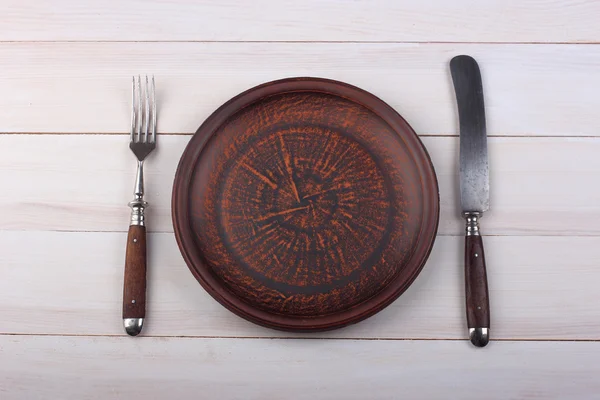 Gabel, Messer und Speiseteller auf hellem Holz — Stockfoto
