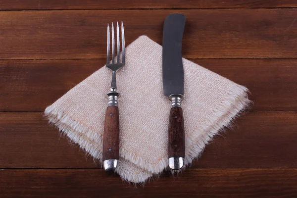 Gabel und Messer auf Serviette auf Holzgrund — Stockfoto