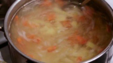 Karışık bir kaşık sebze çorbasını yakın. Yemek pişirme süreci.