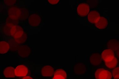 Siyah arka planda kırmızı bokeh ışıkları. Tasarım için Noel ışıkları dokusu.