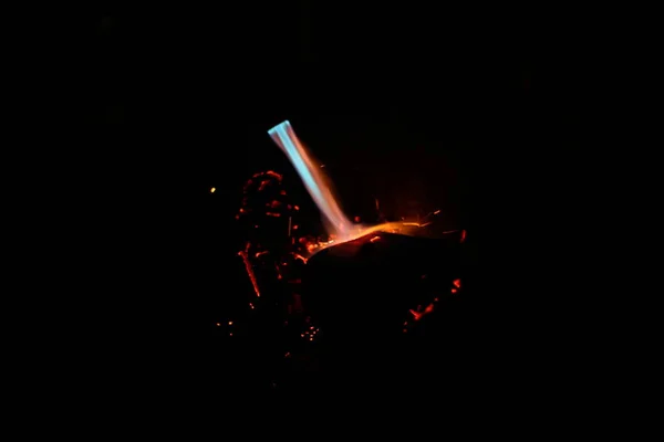 ガスバーナーの青い炎石炭を燃焼させ暗闇の中で黒い背景に火花を散らし — ストック写真