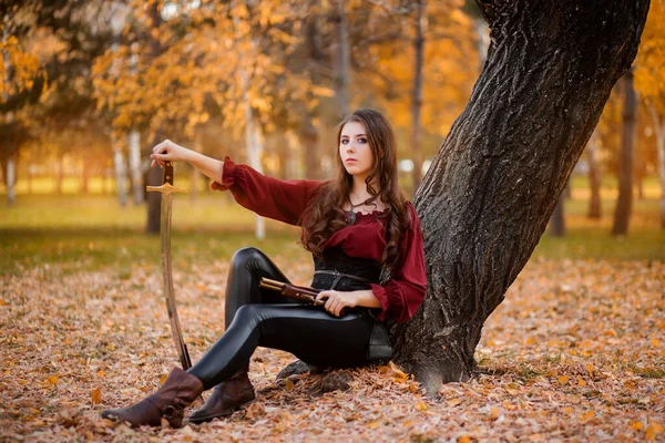 Beautiful Young Woman Saber Pistol Her Hands Sits Tree Autumn — Φωτογραφία Αρχείου