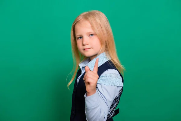 Menina Uniforme Escolar Mantém Indicador Isolado Fundo Verde Gesto Atenção — Fotografia de Stock