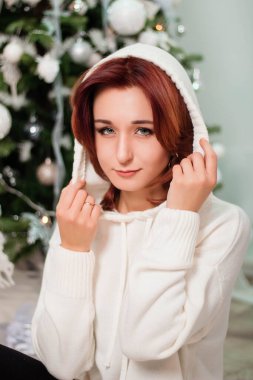 Çekici kadın Noel ağacının yanında oturuyor..