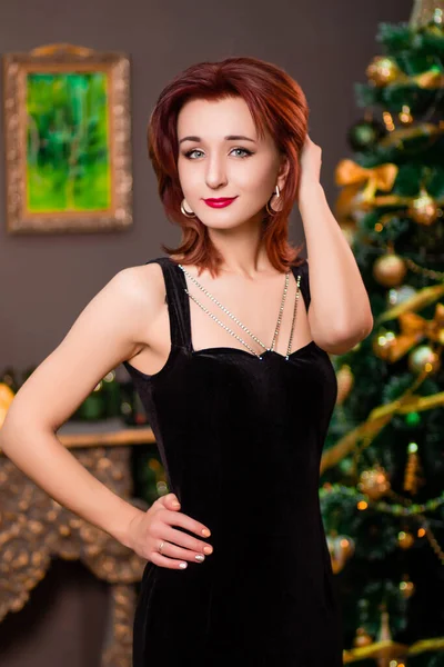 크리스마스 트리의 배경에 포즈를 취하는 드레스를 매력적 여성의 — 스톡 사진