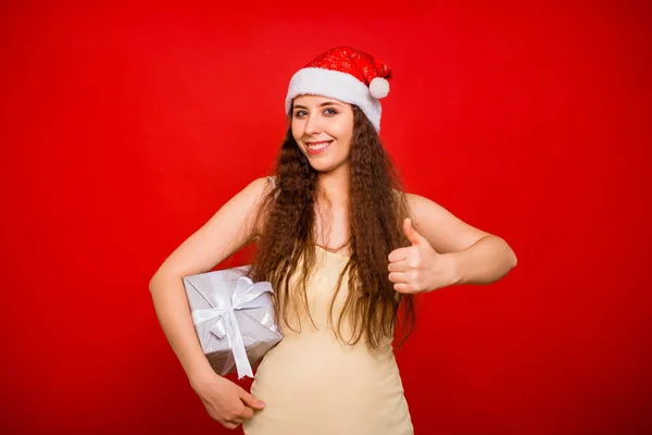 Noel Şapkalı Duygusal Kız Elinde Hediyesiyle Kırmızı Arka Planda Izole — Stok fotoğraf