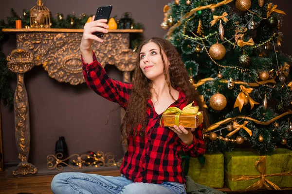 Atrakcyjna Kobieta Robi Sobie Selfie Prezentem Dłoniach Tle Choinki — Zdjęcie stockowe