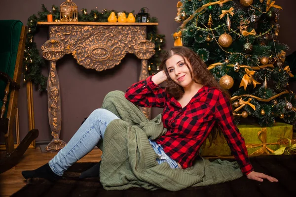 Young Woman Sits Wrapped Plaid Backdrop Christmas Tree Fireplace — Stock Photo, Image