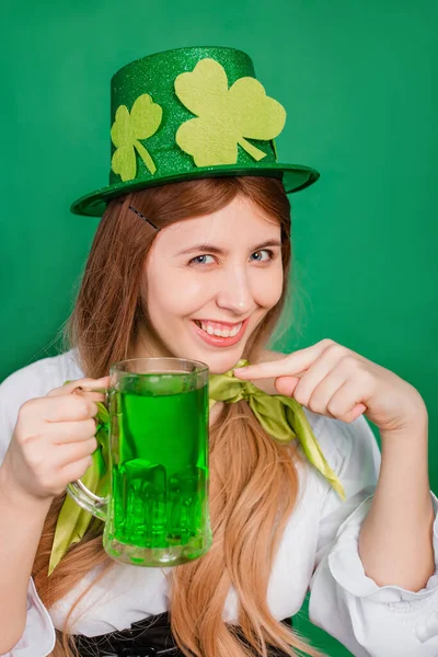 緑の背景に隔離された緑のビールのマグカップを保持シャムロックで飾られたお祝いの聖人パトリックの日の衣装や帽子の女性 — ストック写真