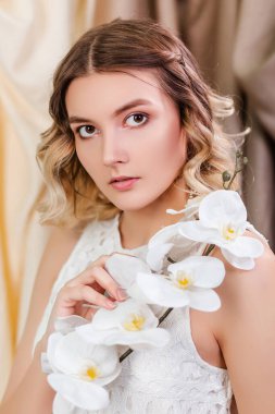 Ellerinde beyaz çiçekler olan güzel bir genç kadının portresi..