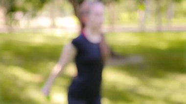 Dambıllarla egzersiz yapan bokeh 'ten ince, atletik kadına odaklanın. Yaz parkında spor.