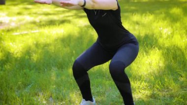 Kamera baştan aşağı hareket ediyor. Spor üniforması giymiş genç ve çekici bir kadın. Parktaki spor aktiviteleri. Sağlıklı yaşam tarzı kavramı.