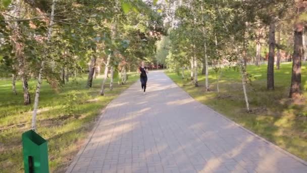 Uma Jovem Mulher Esbelta Corre Longo Beco Parque Verão Conceito — Vídeo de Stock