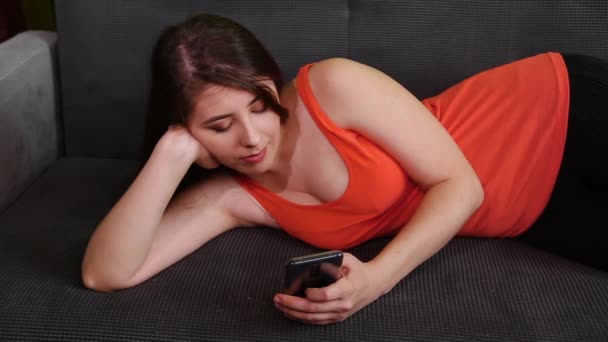 Atractiva Joven Mujer Está Acostada Sofá Con Teléfono Inteligente Sus — Vídeo de stock