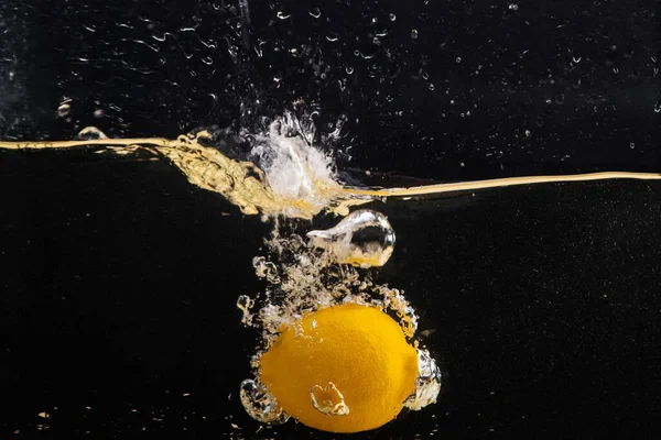 Свежий Желтый Лимон Падает Воду Брызгами Воды Воздуха Пузырьки Изолированные — стоковое фото