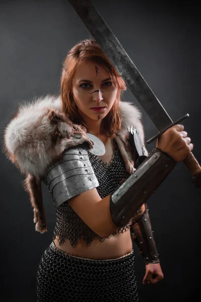 一个穿着链甲 肩上披着极地狐狸毛的中世纪女战士的画像 她站在黑暗的背景上 手里拿着一把剑 女战士的轮廓 — 图库照片