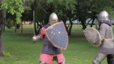 İki ortaçağ savaşçısının tam teçhizatlı zırhları ve kalkanları vardı. Parktaki şövalyeler düellosu.