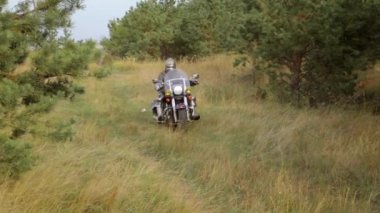 Zırhı, zırhı, zırhı ve kaskı olan bir ortaçağ savaşçısı motosiklet sürüyor. Bisiklet Şövalyesi konsepti. Sürücü güvenilir bir koruma altında..