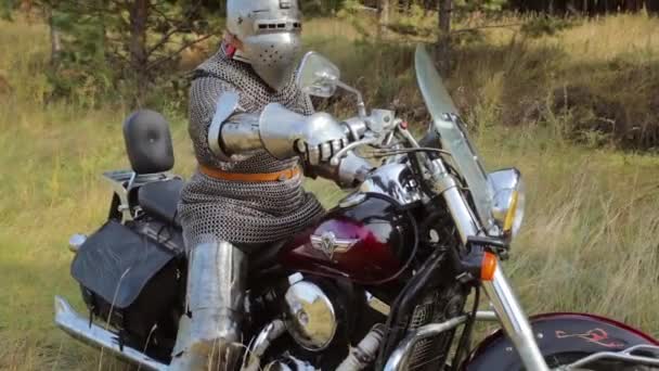 Zırhlı Bir Ortaçağ Şövalyesi Ormanın Arka Planında Motosikletin Üstünde Oturur — Stok video