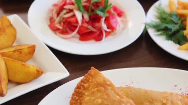 Pürüzsüz kamera hareketleri ve bir restoranda masanın üzerindeki farklı yemeklere odaklanma..