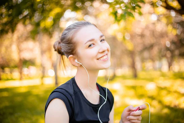 Jonge Sportieve Vrouw Zit Het Park Luistert Naar Muziek Koptelefoon — Stockfoto