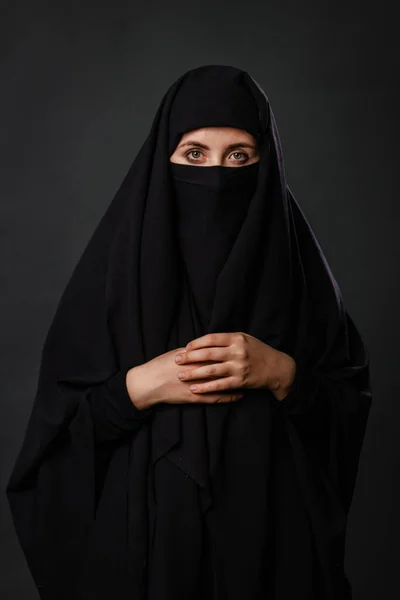 一个穿着黑色罩袍的年轻成年女子的画像 其隐藏的脸与黑色背景隔离 — 图库照片