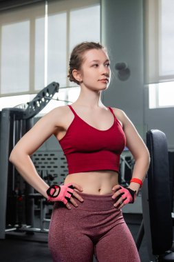 Spor kıyafetli güzel bir bayan spor salonunda poz veriyor..