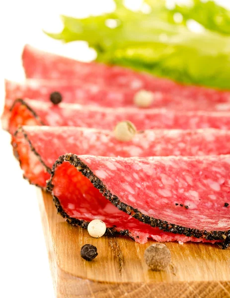 Tranches de salami sur la planche à découper — Photo