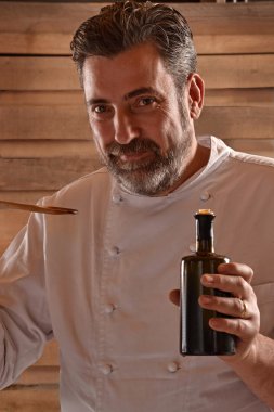 Sızma zeytinyağı şişesi elinde Şef