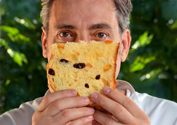 Panettiere ritratto mangiare e gustare fetta di panettone fresco — Foto Stock