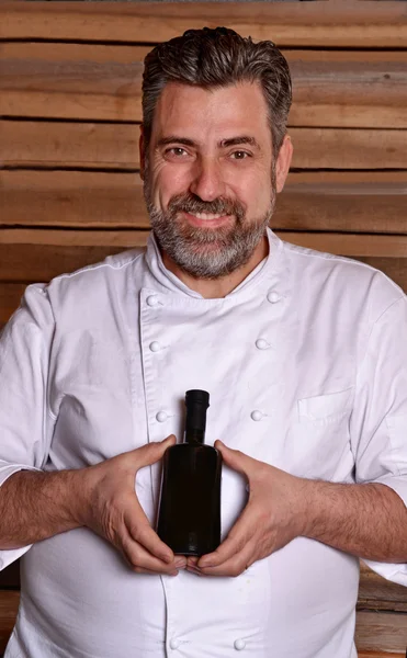 Chef con bottiglia di olio extra vergine di oliva — Foto Stock