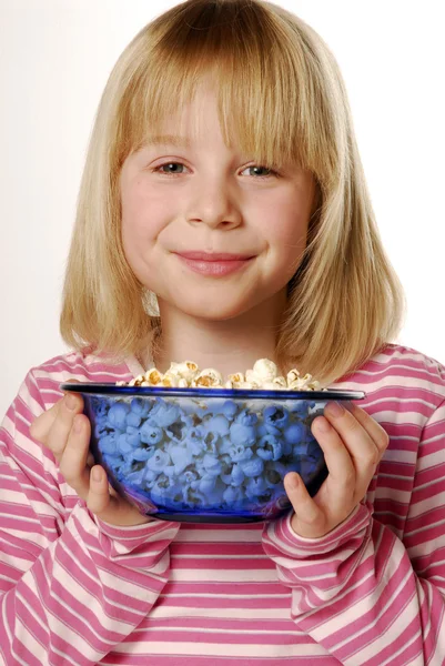 Liten blond flicka äter popcorn. — Stockfoto